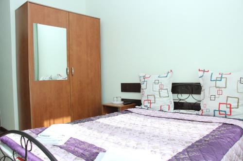 a bedroom with a bed and a wooden cabinet at Zhaylau Hotel in Shchūchīnsk