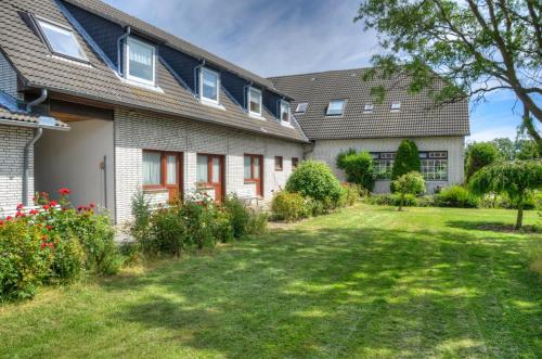 an exterior view of a house with a yard at Hotel Sonneninsel Fehmarn in Fehmarn