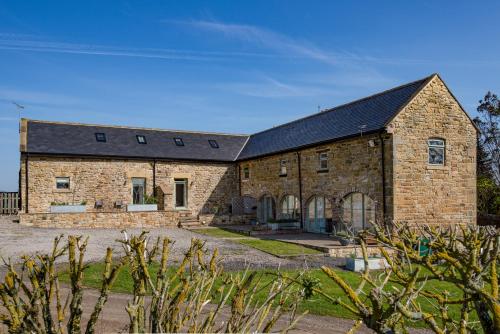 ein altes Steinhaus mit schwarzem Dach in der Unterkunft Riding Farm in Gateshead