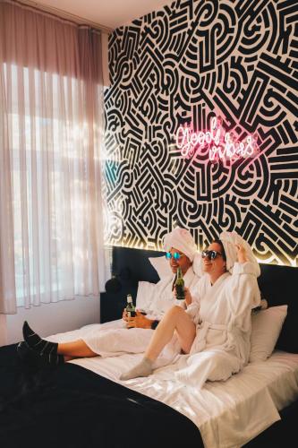 two women in towels sitting on a bed at Hotel Marienplatz Podgorica in Podgorica