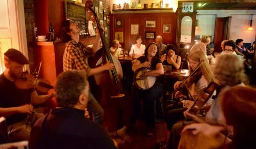 a group of people in a bar playing instruments at BallyV House: Private King Room with en-suite bathroom, breakfast, near Cliffs of Moher in Liscannor