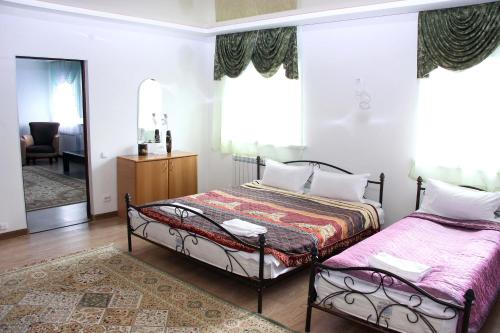 a bedroom with two beds and a mirror at Zhaylau Hotel in Shchūchīnsk