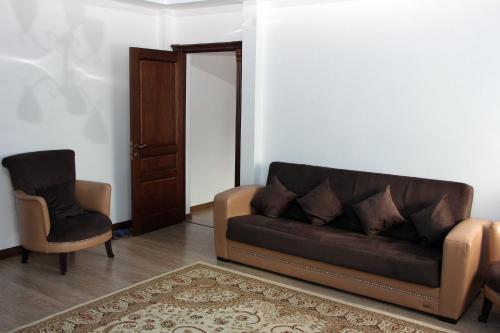 a living room with a couch and a chair at Zhaylau Hotel in Shchūchīnsk