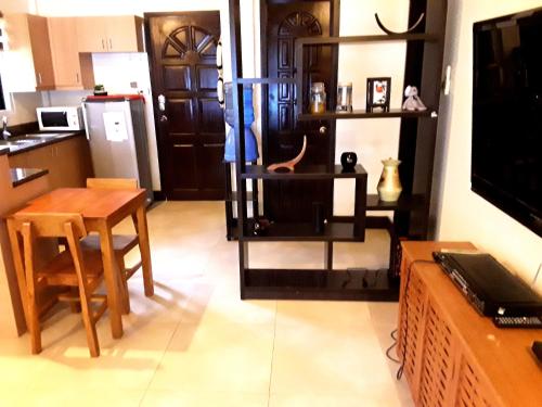 a kitchen with a table and a kitchen with a refrigerator at Adayo Cove Resort in Siquijor