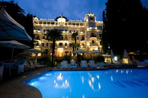 a hotel with a swimming pool in front of a building at Villa Elena Hotel & Residences in Yalta