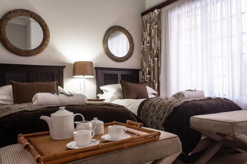 a hotel room with two beds and a tray with tea pots at Oyster Cottage in Durban