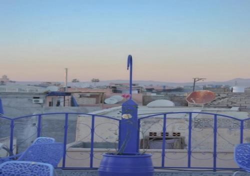 a blue fence with chairs in front of a building at Riad Dar Essassi 23 in Marrakech
