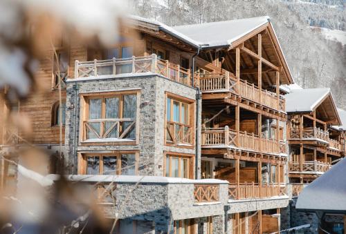 a large wooden building with snow on it at Wildkogel Resorts - DAS Bramberg in Bramberg am Wildkogel