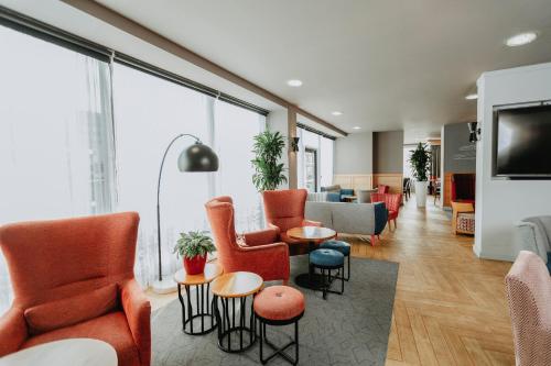 a living room with orange chairs and a couch at Ramada Encore Newcastle-Gateshead in Newcastle upon Tyne