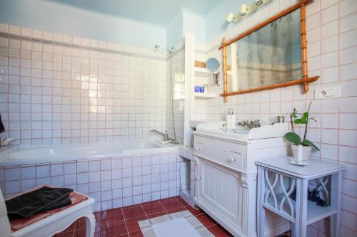 a bathroom with a tub and a sink and a mirror at Muller's Bed & Breakfast in Bargemon