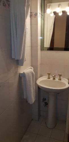 a bathroom with a sink and a mirror and towels at Primacy Apart Hotel in Mar del Plata