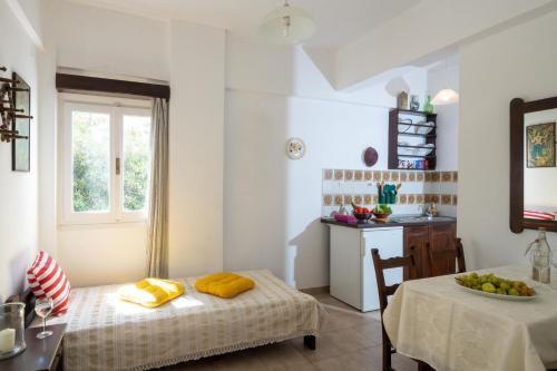 a room with a bed and a table and a kitchen at Margarita Apartments in Ierápetra