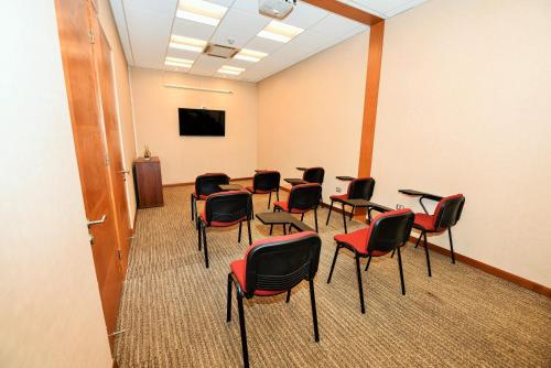 a room with chairs and a table and a screen at Geotel Antofagasta in Antofagasta