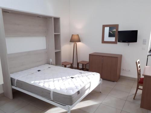 a bedroom with a bed and a table and a tv at VVF Résidence Anglet in Anglet