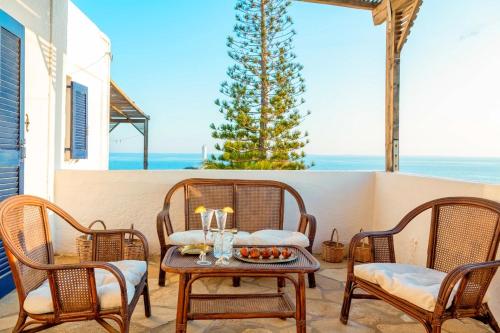 a patio with chairs and a table with a bowl of fruit at Margarita Apartments in Ierápetra