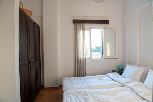 a bedroom with a bed and a window at Margarita Apartments in Ierápetra