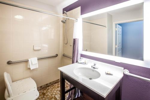 W łazience znajduje się umywalka, toaleta i lustro. w obiekcie La Quinta by Wyndham Lubbock North w mieście Lubbock
