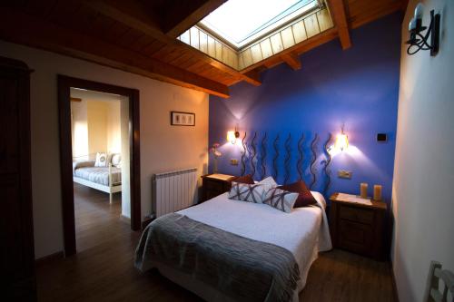 1 dormitorio con 1 cama con pared azul en Casa El Altero, en Codo