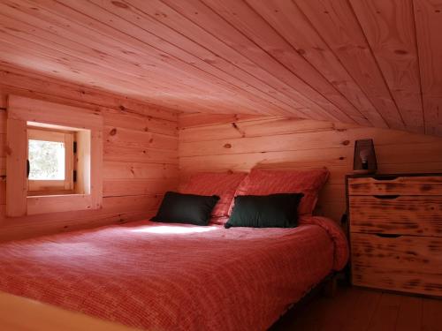 a bedroom with a bed in a log cabin at La cabane des Pachous in Tourves