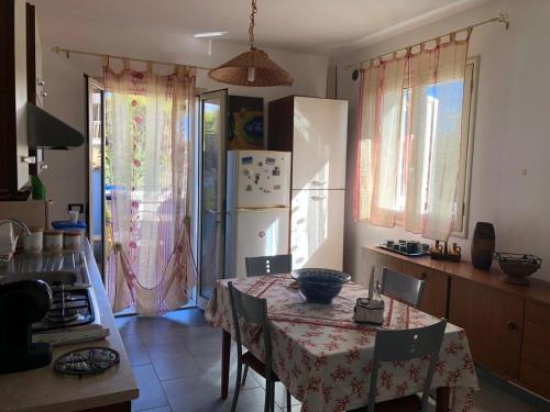 een keuken met een tafel en een koelkast bij Villetta di Giusy in Marina di Modica