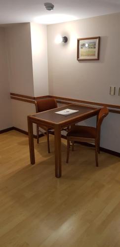 a wooden table and a chair in a room at Primacy Apart Hotel in Mar del Plata