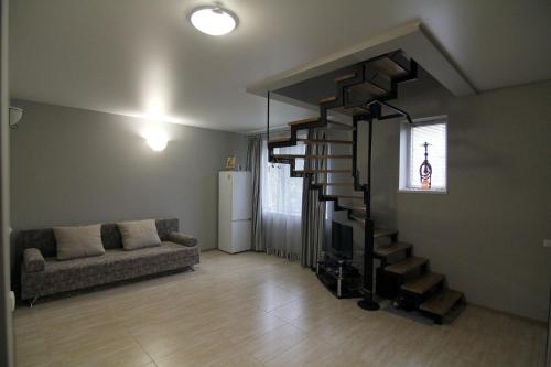 a living room with a couch and a spiral staircase at WOW House Lviv in Lviv