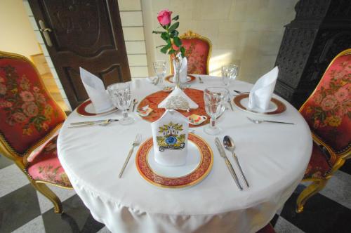 a table with a white table cloth and a vase on it at Zamek Pod Brzozami, Wynajem Pokoi in Krynica Zdrój