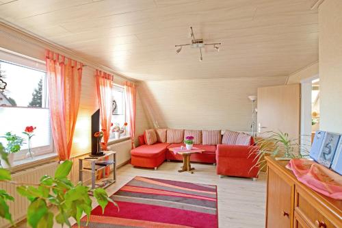 a living room with a red couch and a table at Ferienwohnung Itzehoe in Itzehoe