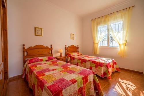 a bedroom with two beds and a window at Chalet Pedro I in Conil de la Frontera