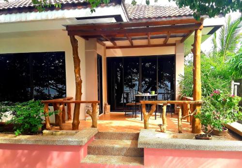 a porch of a house with a wooden pergola at Adayo Cove Resort in Siquijor