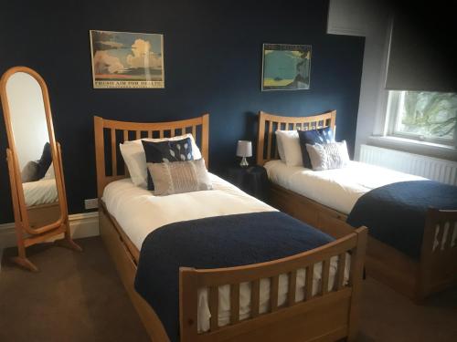 2 camas en un dormitorio con paredes azules en The Weir Hotel, en Walton-on-Thames