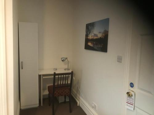 a room with a desk and a lamp on a wall at The Weir Hotel in Walton-on-Thames