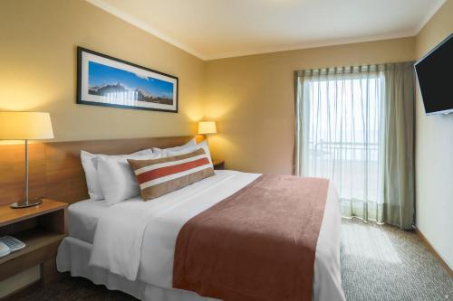 a hotel room with a large bed and a window at Geotel Antofagasta in Antofagasta