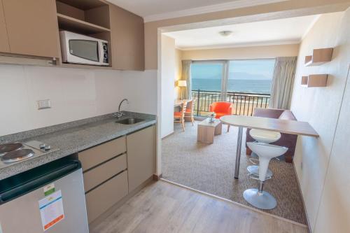 a kitchen with a table and a view of the ocean at Geotel Antofagasta in Antofagasta