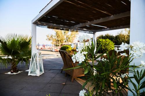 a pergola with white flowers on a patio at Hotel Enterprise in Montalto di Castro