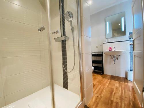 een douche met een glazen deur in de badkamer bij Villa Anna - Kleine Anna in Heringsdorf