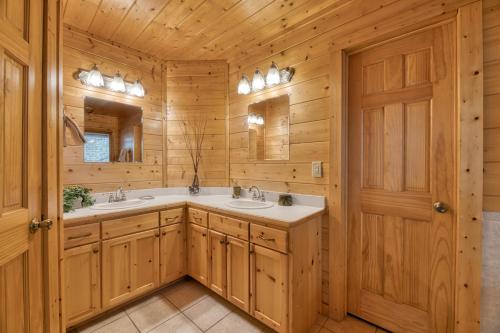 a bathroom with two sinks and two mirrors at Country Living by Venture Smoky Mountains in Sevierville