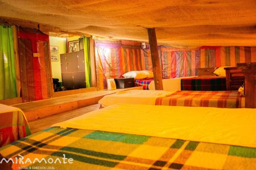 a hotel room with two beds with colorful curtains at Miramonte Hostal in Paipa