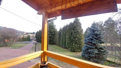 a window of a porch with a christmas tree at Sielanówek - Orzechowa Chatka z sauną wanną termalną jacuzzi in Żywiec