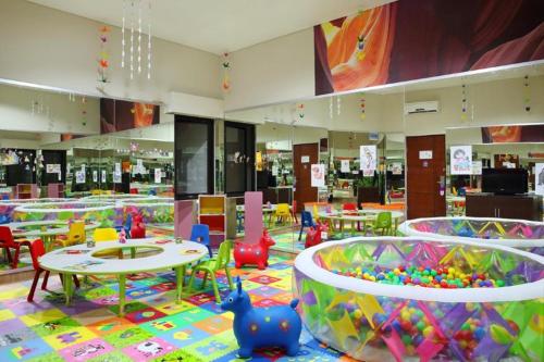 a childrens play area with tables and chairs and toys at Kuta Central Park Hotel in Kuta