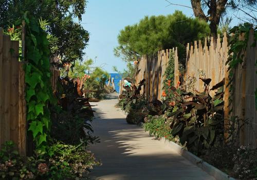 a garden path with a wooden fence and a sidewalk at Camping San Damiano in Biguglia