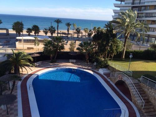 a swimming pool with a view of the beach at 1 Linea Playa San Juan in Alicante