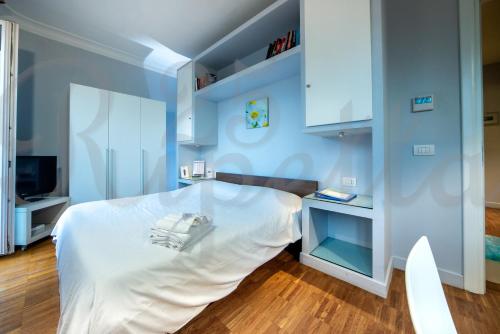 a bedroom with a white bed and a television at Ripetta 25 Prestige Rooms in Rome