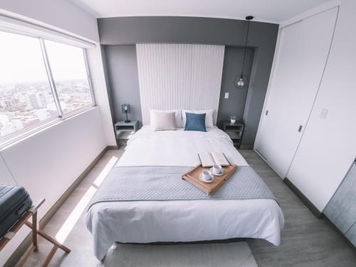 ein Schlafzimmer mit einem großen Bett und einem Tablett darauf in der Unterkunft Trendy Host Connect, Barranco in Lima