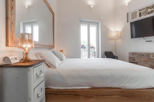 a bedroom with a white bed with a mirror and a phone at New Luxus Apartment in Gaeta with sea view on harbour in Gaeta