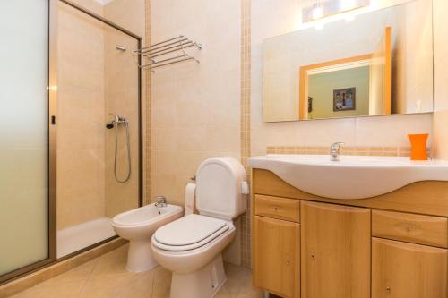 um banheiro com vaso sanitário, pia e chuveiro em Villa Engiadina by ALGARVEMANTA na Manta Rota