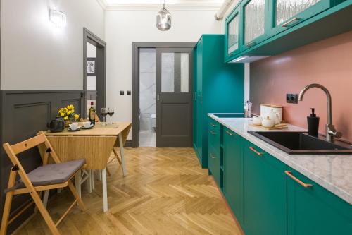 a kitchen with green cabinets and a wooden table at LUXURY Apartment at the Main Square in Krakow