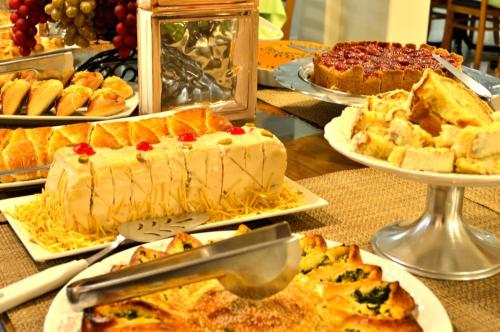 a table with many different types of cakes and pies at Santa Mônica Palace Hotel in Corumbá