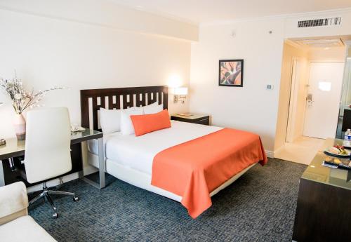 a hotel room with a bed and a desk at The Jamaica Pegasus Hotel in Kingston