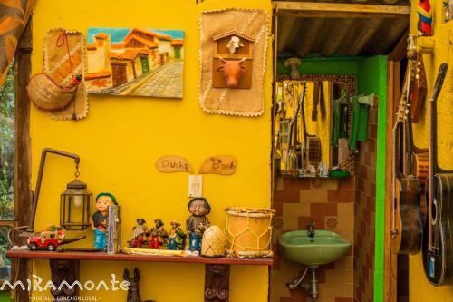 a yellow wall with toy figurines on a table at Miramonte Hostal in Paipa